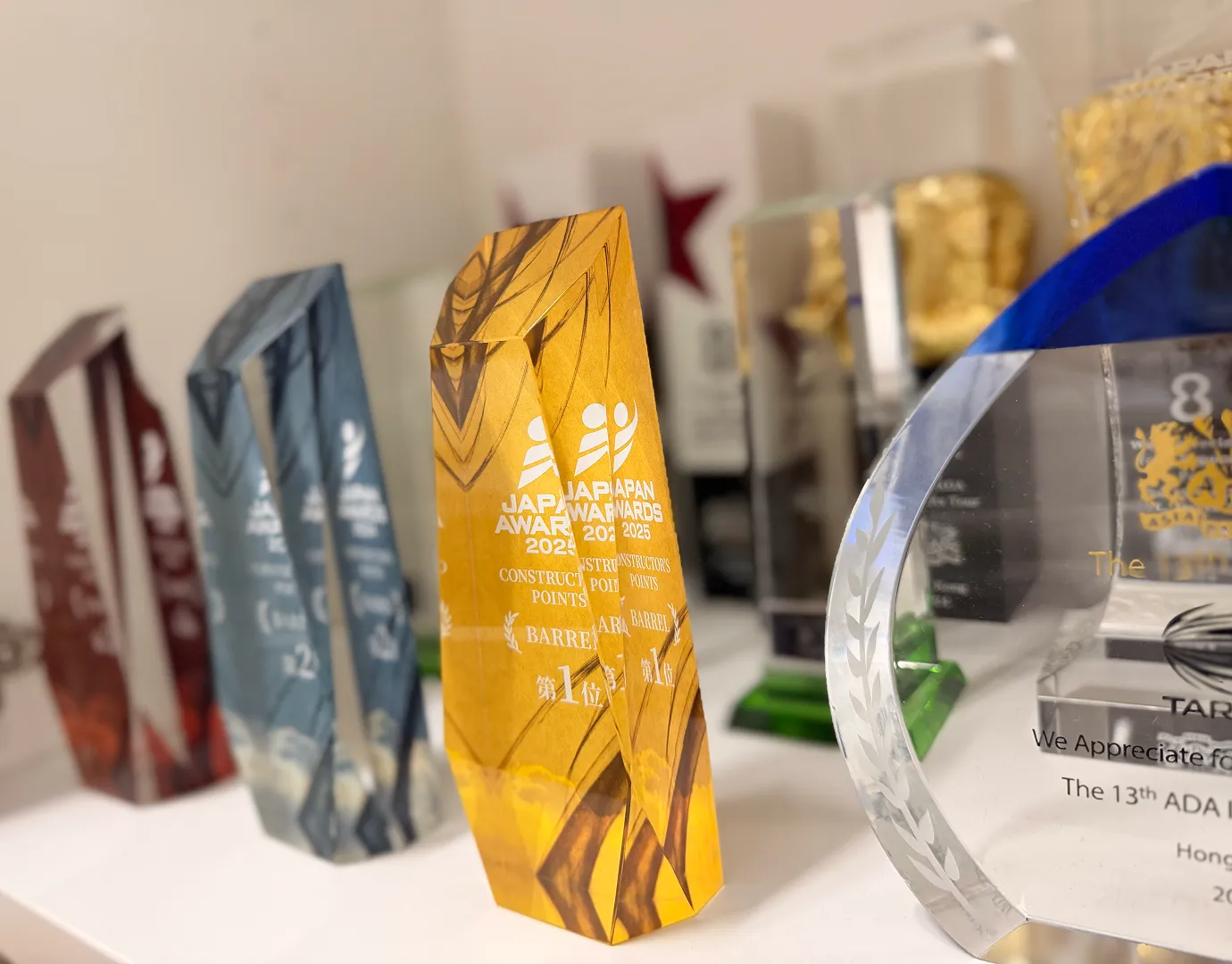 JAPAN AWARDSをはじめとする受賞トロフィーが並ぶ様子